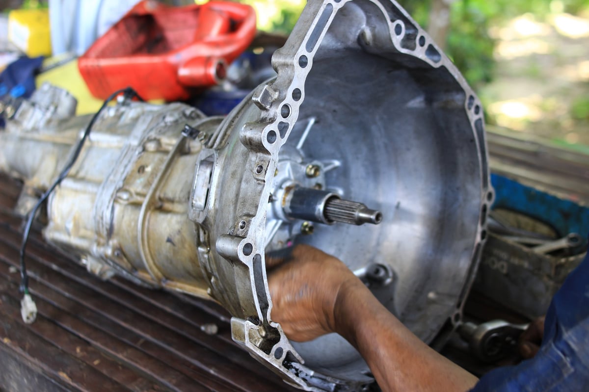 Mechanic rebuilding a car transmission by hand